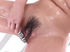 TubeBigCock presents: Japanese teen in bikini oils up her hairy pussy